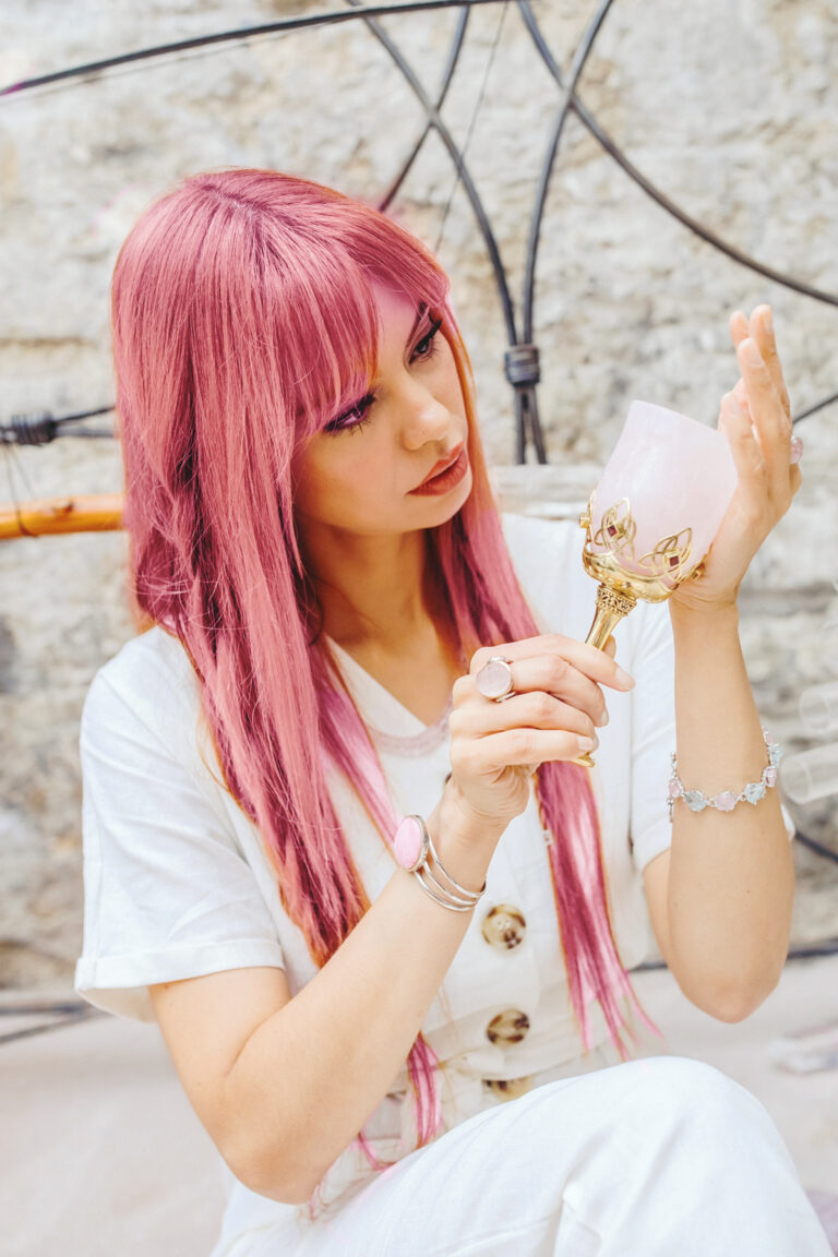Mujer de cabello rosa con cristales de sanación